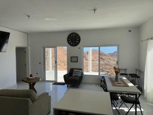 a living room with a clock on the wall at Hermosa casa con vista al mar y las montañas in Salalito
