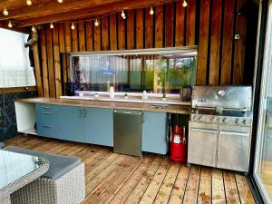 cocina con armarios azules y suelo de madera en Lincontournable - Jaccuzi-Piscine-Sauna-Hammam, en Challans