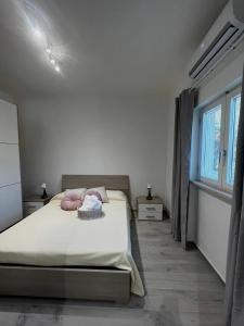 um quarto branco com uma cama e uma janela em Villa Rita em Corato