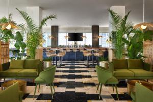a lobby with green chairs and a bar at W Miami in Miami