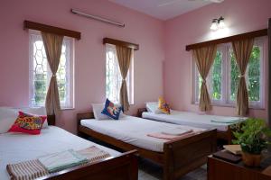 a room with two beds and two windows at The Nerd Nest Kolkata in Kolkata