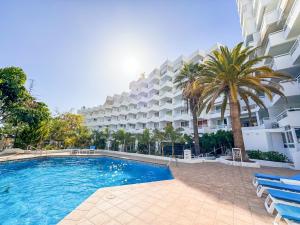 a large apartment building with a swimming pool and palm trees at Ponderosa 210 Casa la Luna in Playa Fañabe