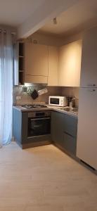 a kitchen with a stove and a microwave at La casa dei Sogni e dintorni in Cervo +11 photos