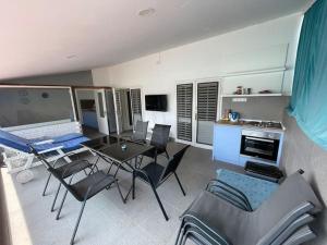 a kitchen and living room with a table and chairs at Riba Fish Neum in Neum