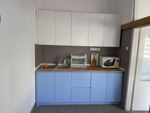 a kitchen with blue and white cabinets and a sink at Riba Fish Neum in Neum