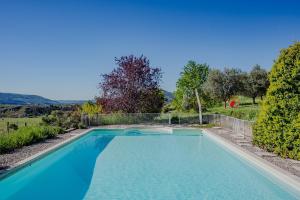 a swimming pool with blue water in a yard at L'Arbre d'Alice in Ongles