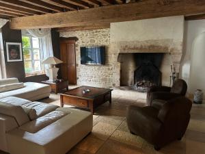 a living room with a couch and a fireplace at Maison coup de cœur in Fauverney