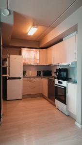 una grande cucina con elettrodomestici bianchi e pavimenti in legno di Panoramisk leilighet 2 a Bodø