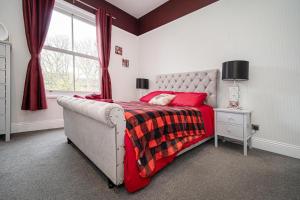 ein Schlafzimmer mit einem Bett mit einer roten Decke und einem Fenster in der Unterkunft Hornsea Holiday House in Hornsea