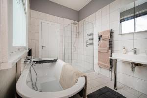 ein Badezimmer mit Badewanne, Waschbecken und Dusche in der Unterkunft Hornsea Holiday House in Hornsea + 14 Fotos