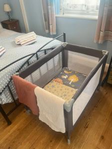 a small crib with a drawer in a bedroom at Florita - Dawlish in Dawlish