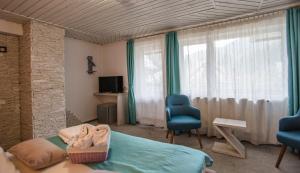 a bedroom with a bed and two chairs and a window at Anelisse Inn in Moieciu de Sus
