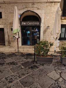 a building with two umbrellas in front of a store at B&B Cateum in Andria