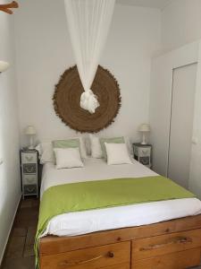 a bedroom with a large bed with a green blanket at Casa Goro Formentera in Playa Migjorn