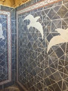ściana wyłożona kafelkami z białymi ptakami namalowanymi na niej w obiekcie Casa Goro Formentera w mieście Playa Migjorn