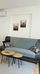 a living room with a blue couch and a table at Rose Apartmans in Jajce