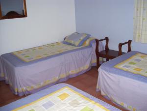 a room with two twin beds and a chair at Casa Concha in Almadén de la Plata +1 photo