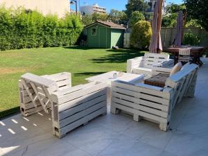 een groep witte stoelen en tafels op een patio bij Studio à toutes proximités in Bry-sur-Marne