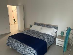 a bedroom with a large bed with a blue blanket at Lettera 22 Apartment in Brindisi