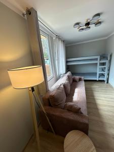 a living room with a couch and a lamp at Oto Domek 1 in Międzyrzecz