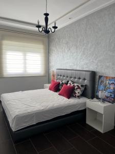 een slaapkamer met een groot bed met rode kussens bij La Remaz 35 in El Jadida
