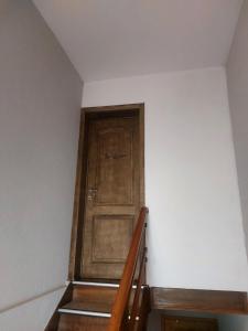 drewniane drzwi w pokoju ze schodami w obiekcie Appartement Luna w mieście Dinant