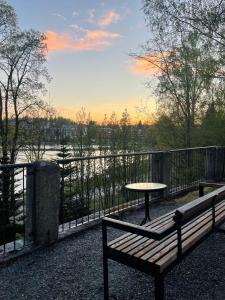 un banco y una mesa en un balcón con vistas en Loft vesinäkymällä & maksuton kadunvarsipysäköinti en Kuopio
