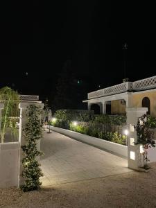 a person walking down a walkway at night at Allivigne Rooms & Pool in Polignano a Mare +35 photos