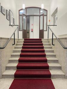 una escalera con alfombra roja y alfombra roja en Loft vesinäkymällä & maksuton kadunvarsipysäköinti en Kuopio