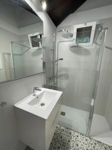 biała łazienka z prysznicem i umywalką w obiekcie La casita de Mazo w mieście Mazo