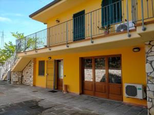 a yellow building with a balcony and doors at CASA ELGA in Borgo a Buggiano
