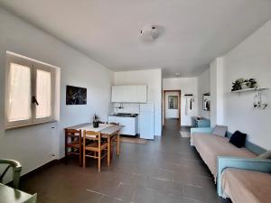 uma cozinha e sala de estar com uma mesa e um sofá em Villa Amica em Vieste