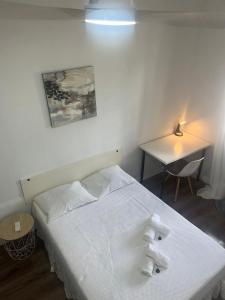 a bedroom with a white bed with towels on it at MEDITERRANEAN HOUSE - Habitaciones Privadas en Casa Compartida in Mairena del Aljarafe