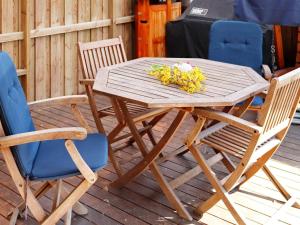 a wooden table with two chairs and a bouquet of flowers at 6 person holiday home in LAHOLM-By Traum in Laholm +8 photos