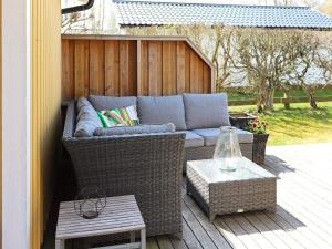 a patio with a couch and a table on a deck at 6 person holiday home in LAHOLM-By Traum in Laholm