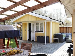 a patio with a yellow house with a roof at 6 person holiday home in LAHOLM-By Traum in Laholm