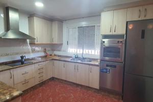 a kitchen with white cabinets and stainless steel appliances at Villa Maruna in Grao de Castellón