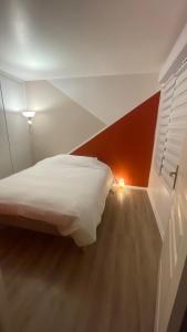 a bedroom with a white bed in a room with a lamp at Paris Ouest Appartment in Courbevoie