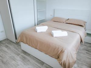 ein Schlafzimmer mit einem Bett mit zwei Handtüchern darauf in der Unterkunft Cosy apartment Fagaras in Făgăraş