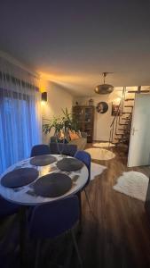 a living room with a table and blue chairs at Panoráma Vendégház Dunabogdány in Dunabogdány