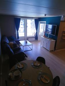 un soggiorno con tavolo e divano di Panoramisk leilighet 2 a Bodø