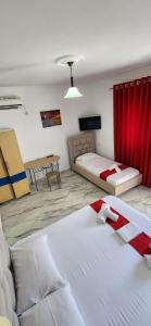 a room with two beds and a red curtain at Koci Apartments in Sarandë