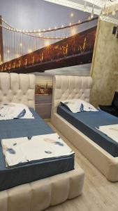 two beds in a room with a bridge in the background at Lela Apartments in Tbilisi City
