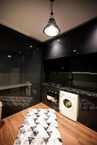 - un lave-linge et un sèche-linge dans une cuisine aux murs noirs dans l'établissement The Palm Terrace Penthouse 3BR - Palm Hills - 280 sqm, au Caire