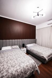 1 dormitorio con 2 camas y pared marrón en The Palm Terrace Penthouse 3BR - Palm Hills - 280 sqm en El Cairo