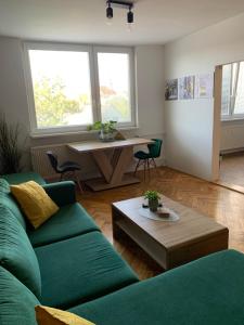 sala de estar con sofá verde y mesa en Victory apartmán en Šamorín