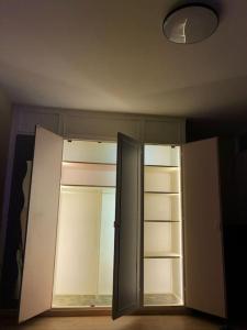 a kitchen with an open cabinet and a light at Beau T2 rénové in Cluses
