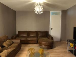 a living room with a couch and a chandelier at Beau T2 rénové in Cluses
