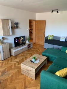 a living room with a couch and a table at Victory apartmán in Šamorín