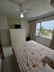 a bedroom with a bed with a view of the ocean at Apartamento Peruibe pé na areia!!! in Peruíbe